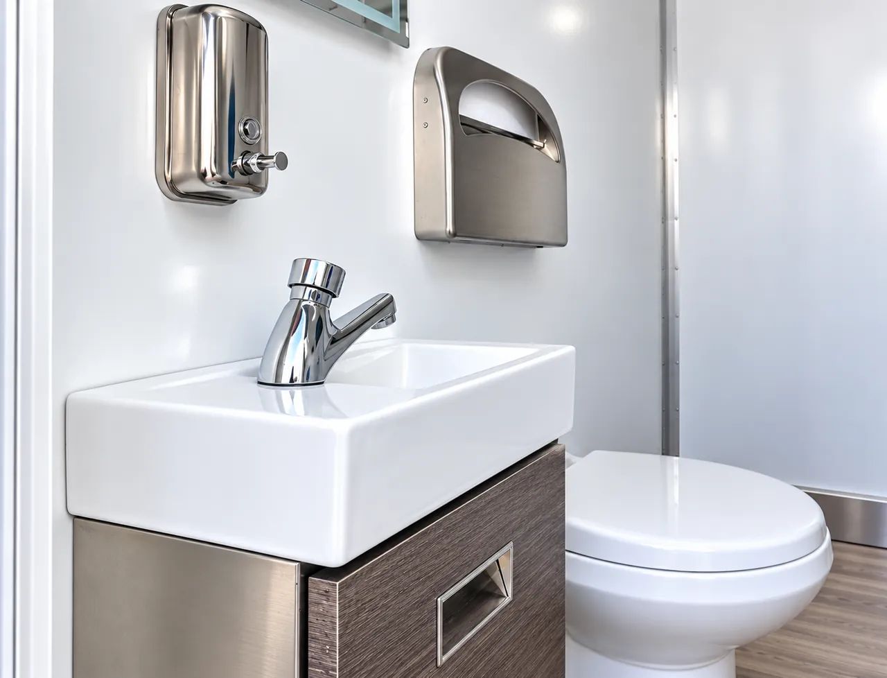 Sink, mirror and toilet inside a mobile restroom trailer