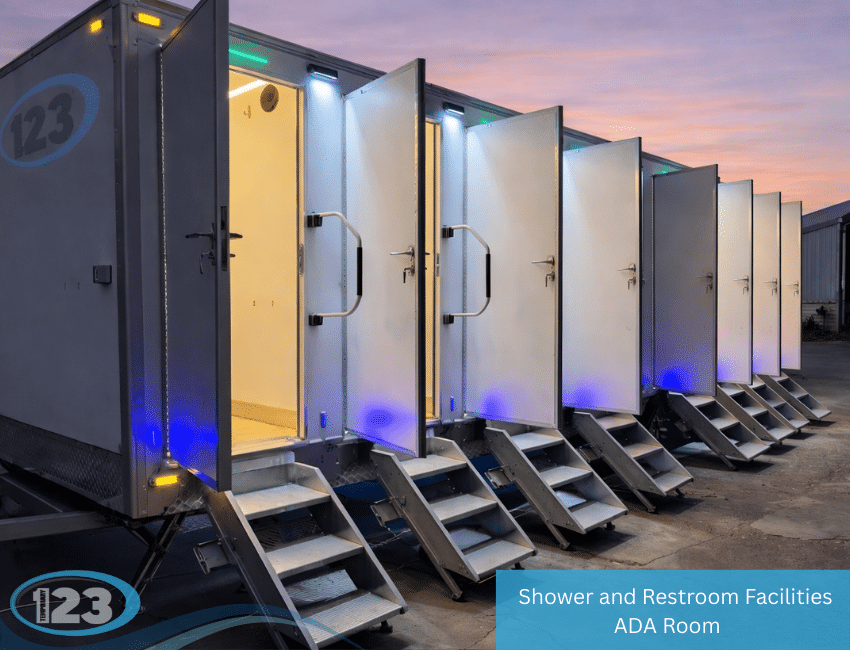 Multi-stall shower and restroom trailer with open doors, entry steps, and exterior lighting at dusk