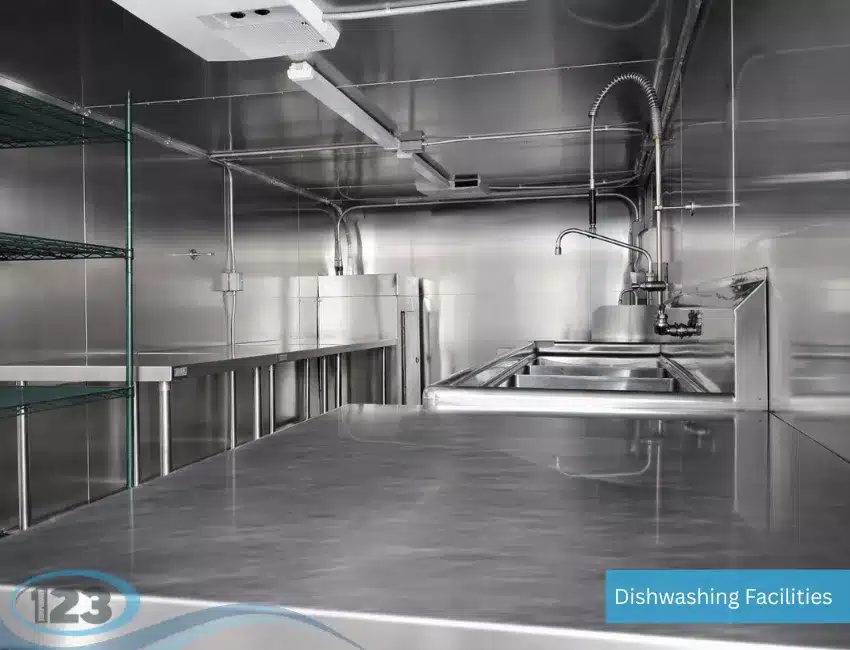 Self-contained dishwashing trailer interior with triple sink setup for washing, rinsing, and sanitizing dishes.