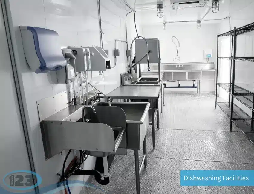 Mobile dish cleaning trailer featuring stainless steel sinks, counters, and professional sanitation equipment.